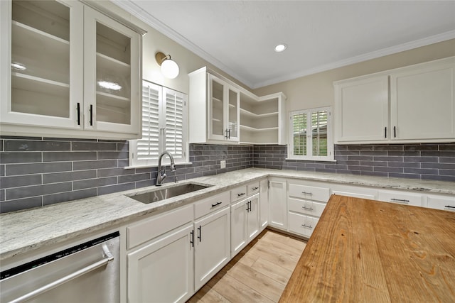 kitchen with backsplash, stainless steel dishwasher, white cabinetry, and sink