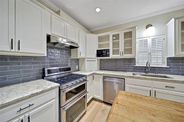 kitchen with white cabinets, appliances with stainless steel finishes, sink, and extractor fan