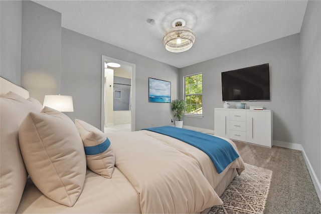 carpeted bedroom featuring connected bathroom and a textured ceiling