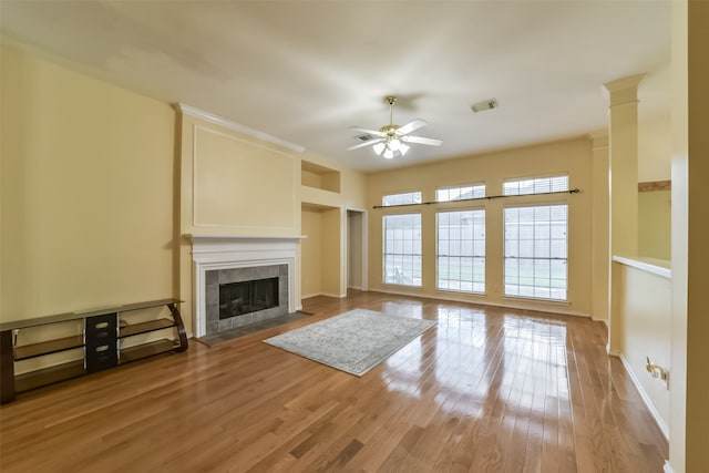 unfurnished living room featuring a fireplace, ceiling fan, and light hardwood / wood-style flooring