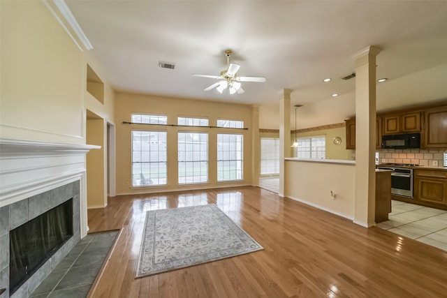 unfurnished living room featuring ceiling fan, hardwood / wood-style flooring, and a high end fireplace