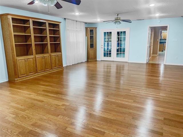 unfurnished living room featuring a textured ceiling, light hardwood / wood-style floors, and ceiling fan