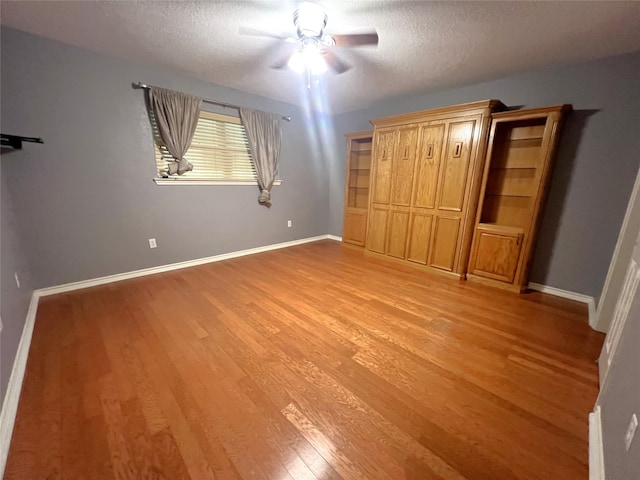 unfurnished bedroom with light wood-type flooring, ceiling fan, and a textured ceiling