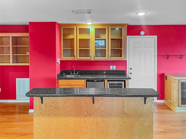 kitchen featuring light hardwood / wood-style floors, kitchen peninsula, and a breakfast bar