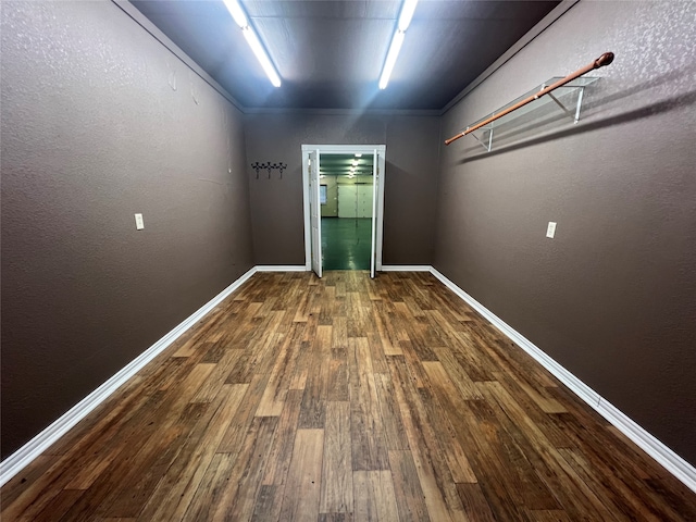 unfurnished room featuring ornamental molding and dark wood-type flooring