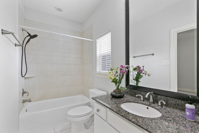 full bathroom featuring tile patterned flooring, tiled shower / bath, vanity, and toilet