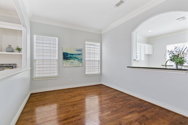 empty room with ornamental molding and dark hardwood / wood-style floors