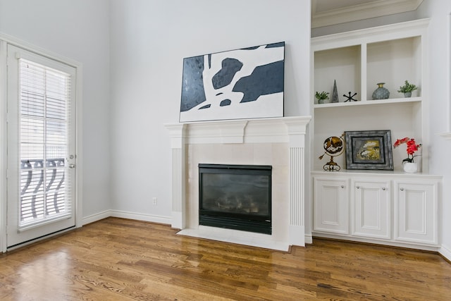 living room featuring a fireplace, ornamental molding, and hardwood / wood-style floors