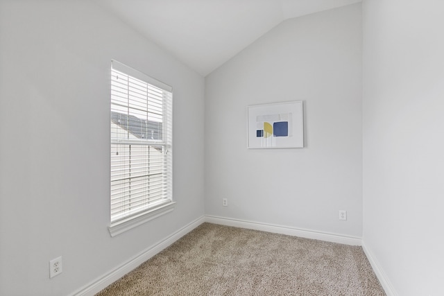 empty room with lofted ceiling and light carpet