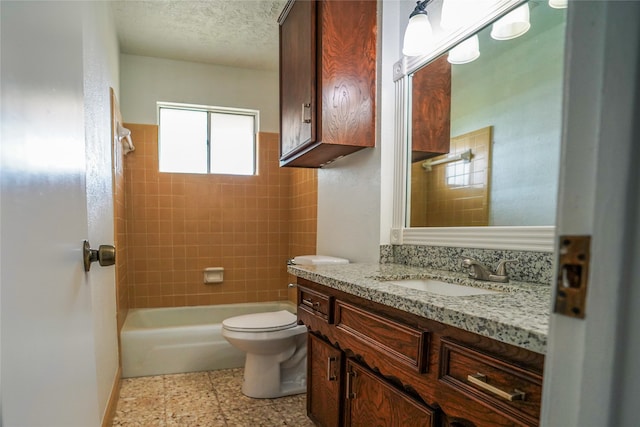 full bathroom with a textured ceiling, tiled shower / bath combo, vanity, and toilet