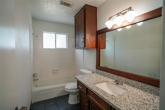 full bathroom with vanity, tiled shower / bath combo, tile patterned flooring, a textured ceiling, and toilet