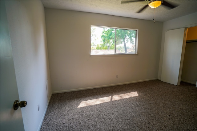 unfurnished bedroom featuring ceiling fan, a textured ceiling, a closet, and carpet flooring