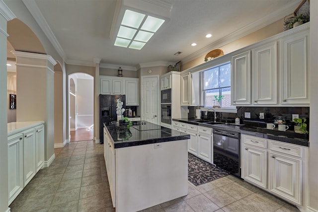 kitchen with backsplash, a center island, white cabinets, and black appliances