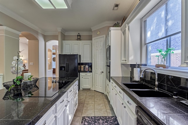 kitchen featuring white cabinets, black appliances, sink, ornamental molding, and light tile patterned floors