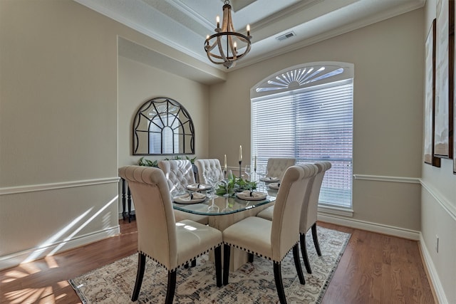 dining room featuring hardwood / wood-style floors, a chandelier, and ornamental molding