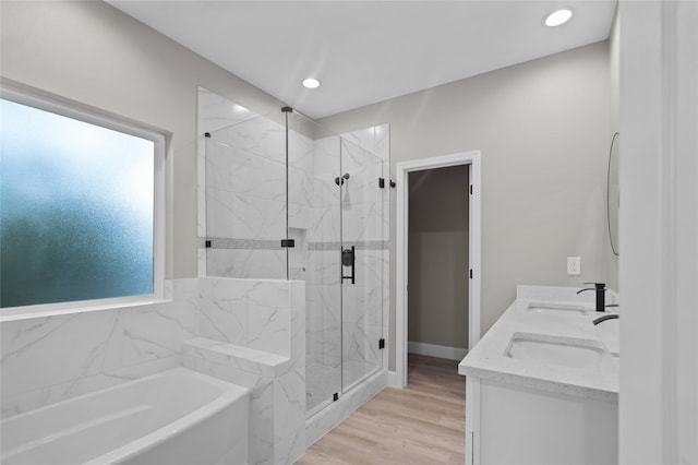 bathroom featuring vanity, hardwood / wood-style floors, and plus walk in shower