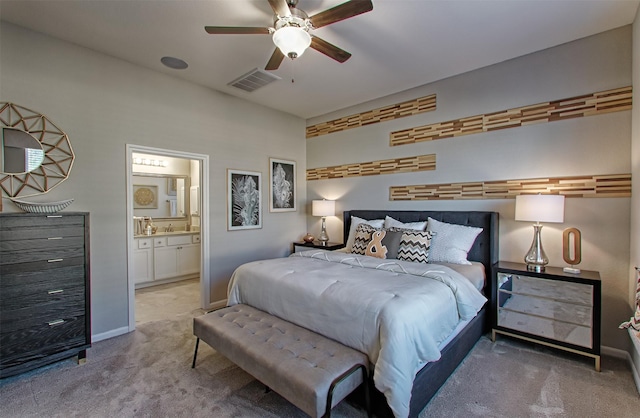 bedroom with ceiling fan, carpet floors, and ensuite bathroom