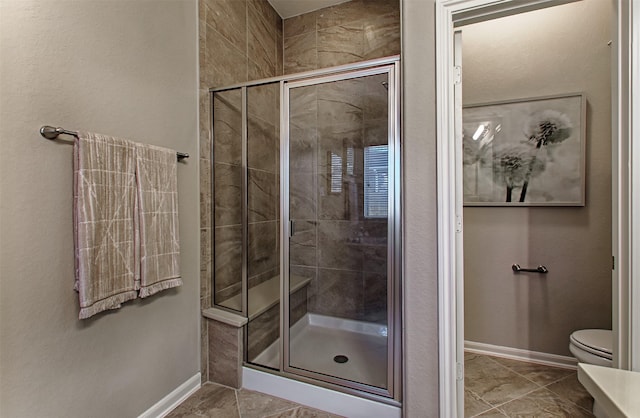 bathroom with toilet and a shower with shower door