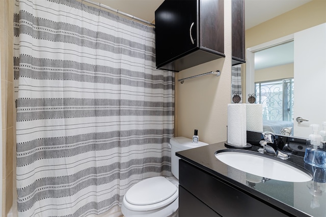 bathroom with curtained shower, vanity, and toilet