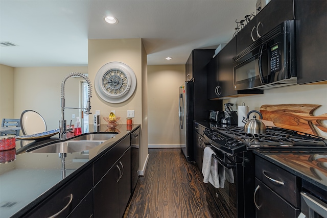 kitchen featuring black appliances, dark hardwood / wood-style flooring, and sink