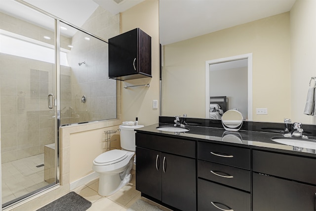 bathroom featuring vanity, tile patterned flooring, toilet, and a shower with door