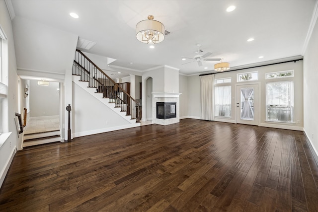 unfurnished living room with ceiling fan, ornamental molding, a multi sided fireplace, and dark hardwood / wood-style flooring