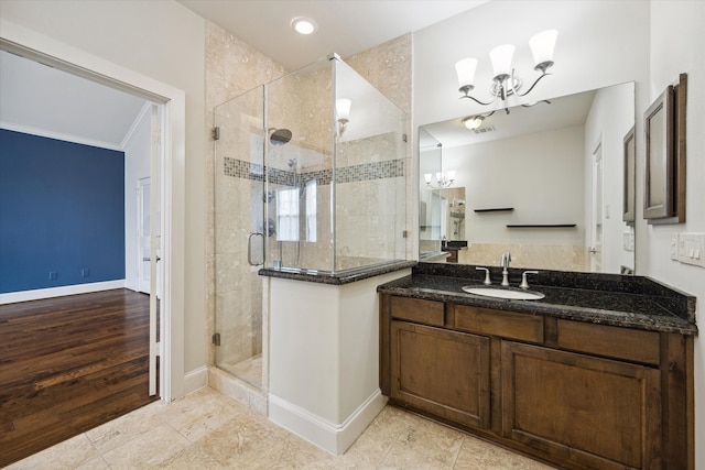 bathroom featuring a shower with shower door, vanity, crown molding, wood-type flooring, and a chandelier