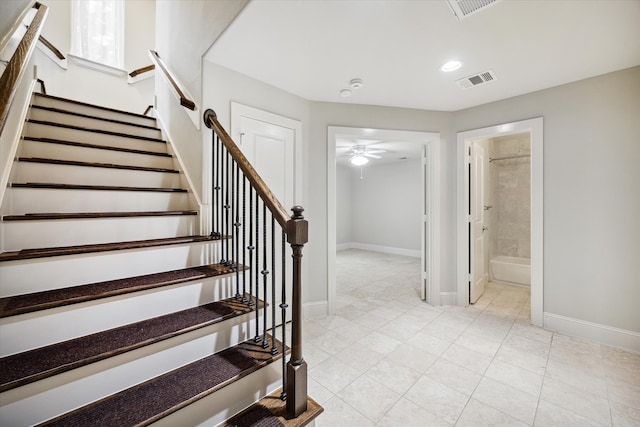 stairs with ceiling fan and tile patterned floors