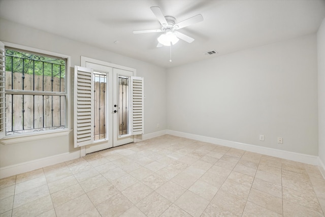 empty room with french doors, ceiling fan, and light tile patterned floors