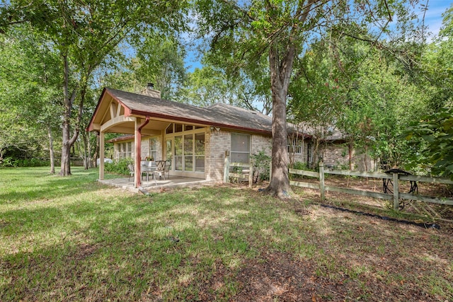 back of property featuring a patio and a yard