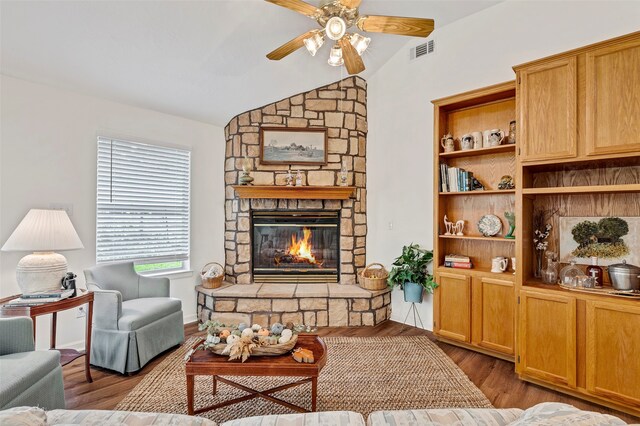 living room featuring ceiling fan, a fireplace, hardwood / wood-style floors, and vaulted ceiling