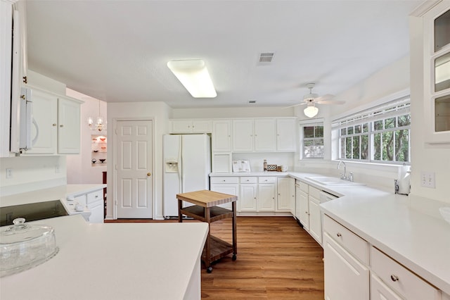 kitchen featuring light hardwood / wood-style floors, sink, white cabinets, white appliances, and ceiling fan