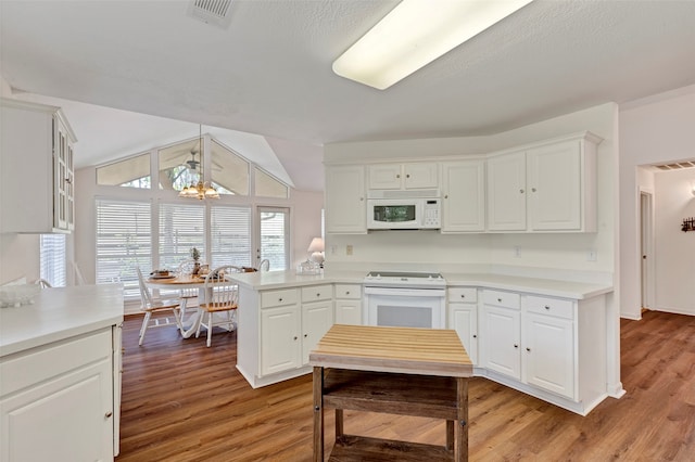 kitchen featuring an inviting chandelier, hardwood / wood-style flooring, white appliances, and white cabinetry