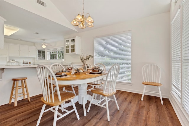 dining room with wood-type flooring, ceiling fan with notable chandelier, plenty of natural light, and lofted ceiling