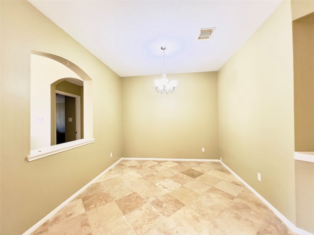 unfurnished room with an inviting chandelier