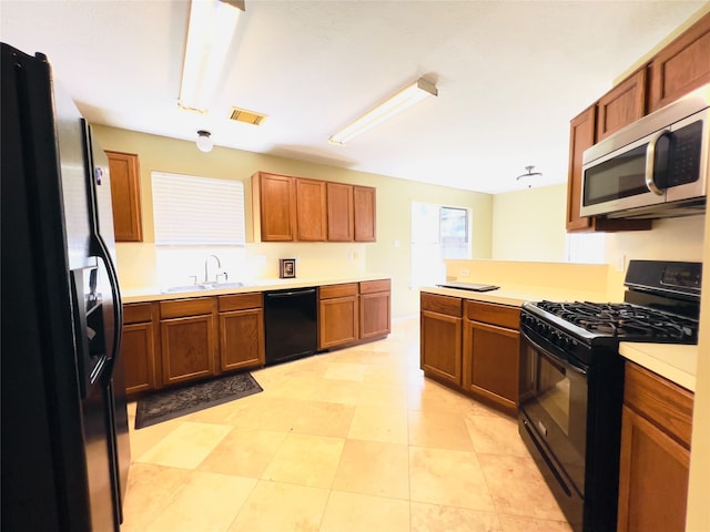 kitchen with kitchen peninsula, sink, and black appliances