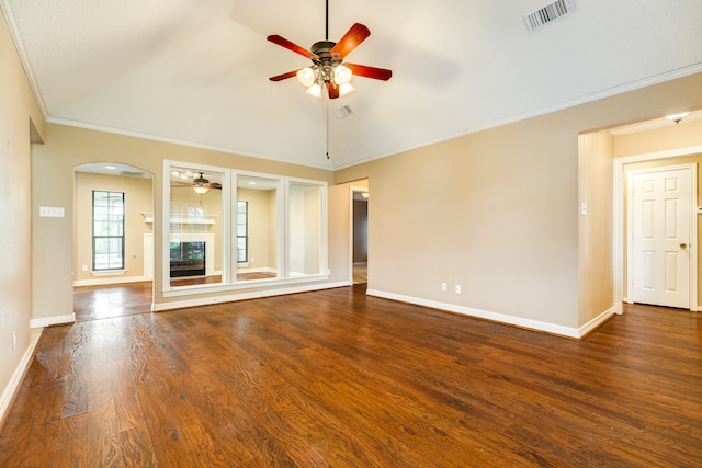 unfurnished living room with crown molding, vaulted ceiling, dark wood-type flooring, and ceiling fan