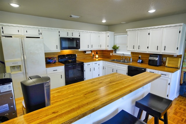 kitchen featuring black appliances, sink, a textured ceiling, and white cabinetry