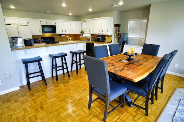 dining space featuring sink and light parquet floors