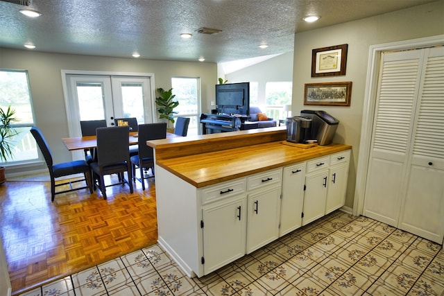 kitchen featuring white cabinets, a wealth of natural light, and a textured ceiling