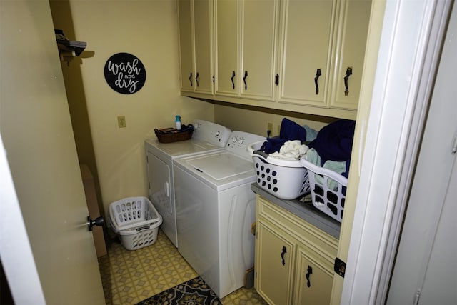 clothes washing area with washing machine and dryer and cabinets