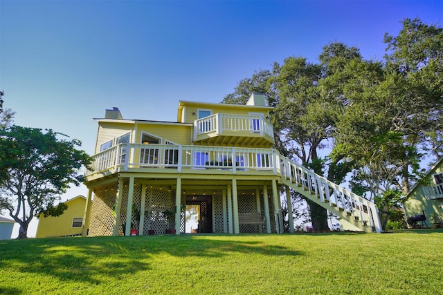 back of house featuring a lawn and a wooden deck