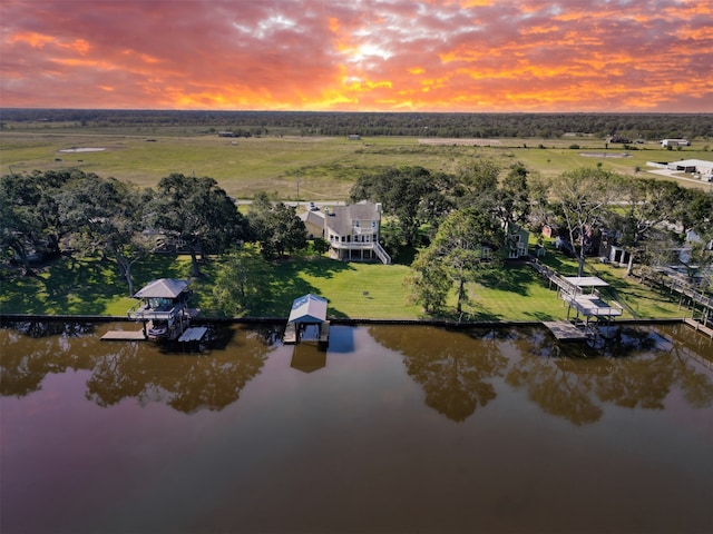 aerial view at dusk with a water view and a rural view