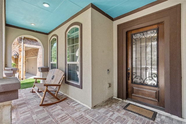 view of exterior entry featuring covered porch