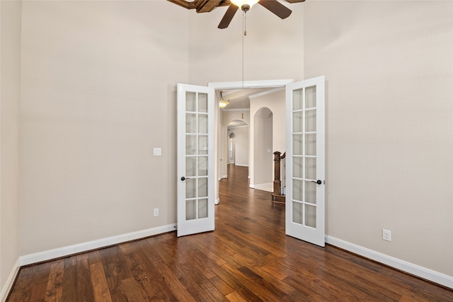 unfurnished room with french doors, a high ceiling, dark wood-type flooring, and ceiling fan