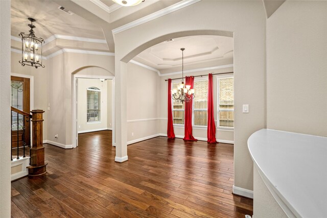 entrance foyer featuring ornamental molding, a tray ceiling, dark hardwood / wood-style floors, and a chandelier