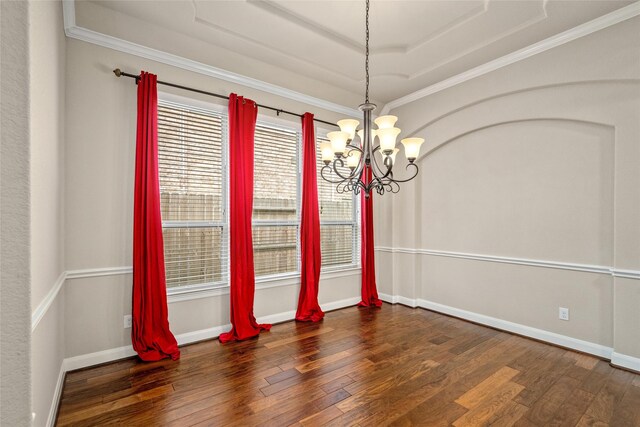 spare room with dark wood-type flooring, crown molding, a chandelier, and a tray ceiling