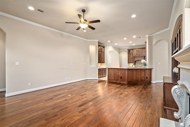 unfurnished living room featuring ornamental molding, dark hardwood / wood-style flooring, and ceiling fan