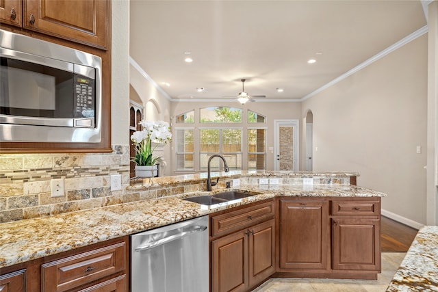 kitchen with stainless steel appliances, ceiling fan, crown molding, and sink