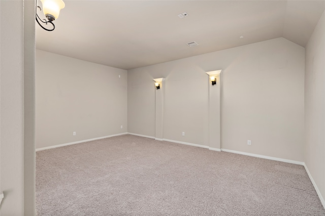 empty room featuring light carpet and lofted ceiling